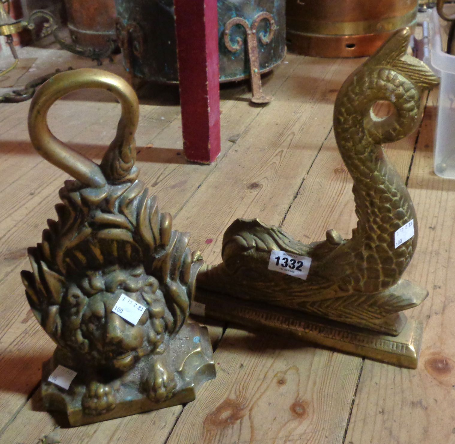 An antique cast brass doorstop of lion head form - sold with a modern similar of grotesque fish