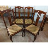 A set of four mahogany framed splat back dining chairs with pierced decoration to backs and