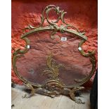 A cast brass and mesh fire screen of Rococo scroll form