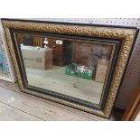 An antique gilt gesso and part ebonised framed oblong wall mirror with later plate