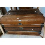 A vintage tin travelling trunk with brown finish and flanking drop handles