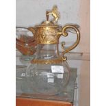 A late 19th Century glass claret jug with gilt metal fittings and lion rampart handle - engraved