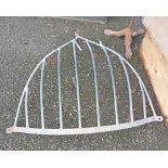 A vintage metal hay rack of curved form