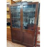 A 1.06m 1930's stained oak book cabinet with leaded glazed panel doors to top and double cupboard