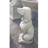 A 70cm high concrete garden statue of a seated dog