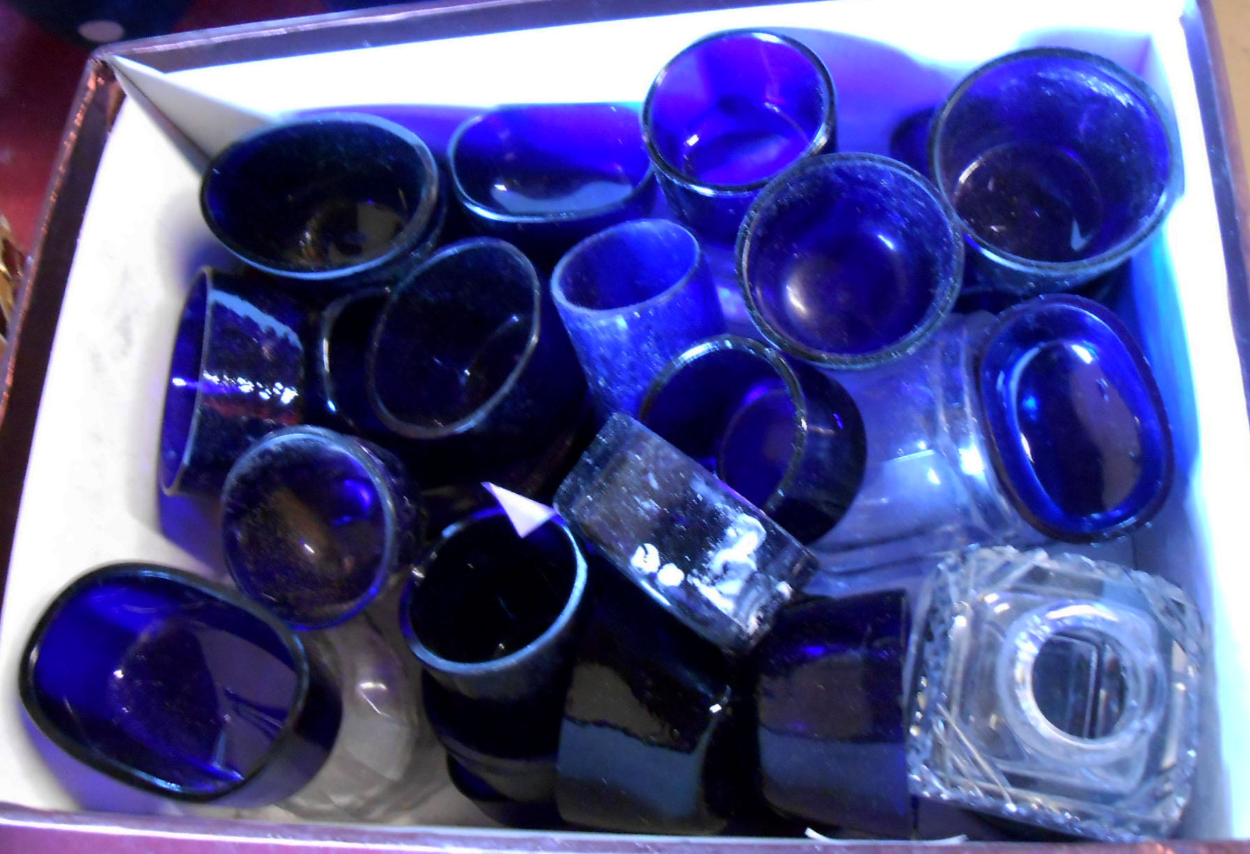 A small box containing a large quantity of blue glass cruet liners, etc.