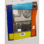 A small leaded wall mirror with coloured glass border and cabochon