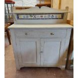 A 1.07m painted wood chiffonier with shelf and tile set raised back, fitted frieze drawer and pair