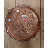 An Arts & Crafts Movement beaten copper charger with repousse decoration depicting sinewy leaves