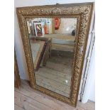 An old gilt gesso framed oblong wall mirror with later painted finish