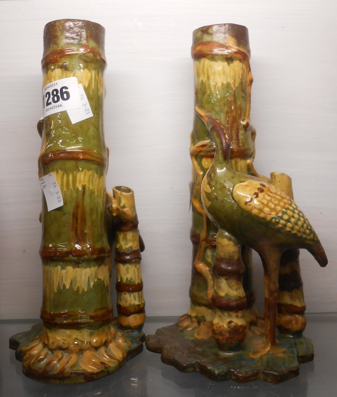 A pair of C.H. Branham Barnstaple art pottery spill vases, each depicting a stork beside a bamboo