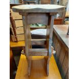 A rustic elm kitchen stool with moulded solid seat, set on shaped standard ends with pegged