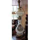 A vintage milk glass table lamp of oil lamp form with transfer printed panel depicting two young