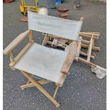 A set of four teak framed folding director's style chairs with slung seats