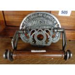 A modern cast iron toilet roll holder with Borough of London WC1 and turned wooden roll holder