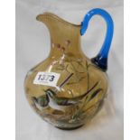A 19th Century amber glass jug with applied blue handle decorated in enamels with a pair of wagtails