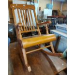 A stained mixed wood lathe back rocking chair, set on simple turned supports with curved rails