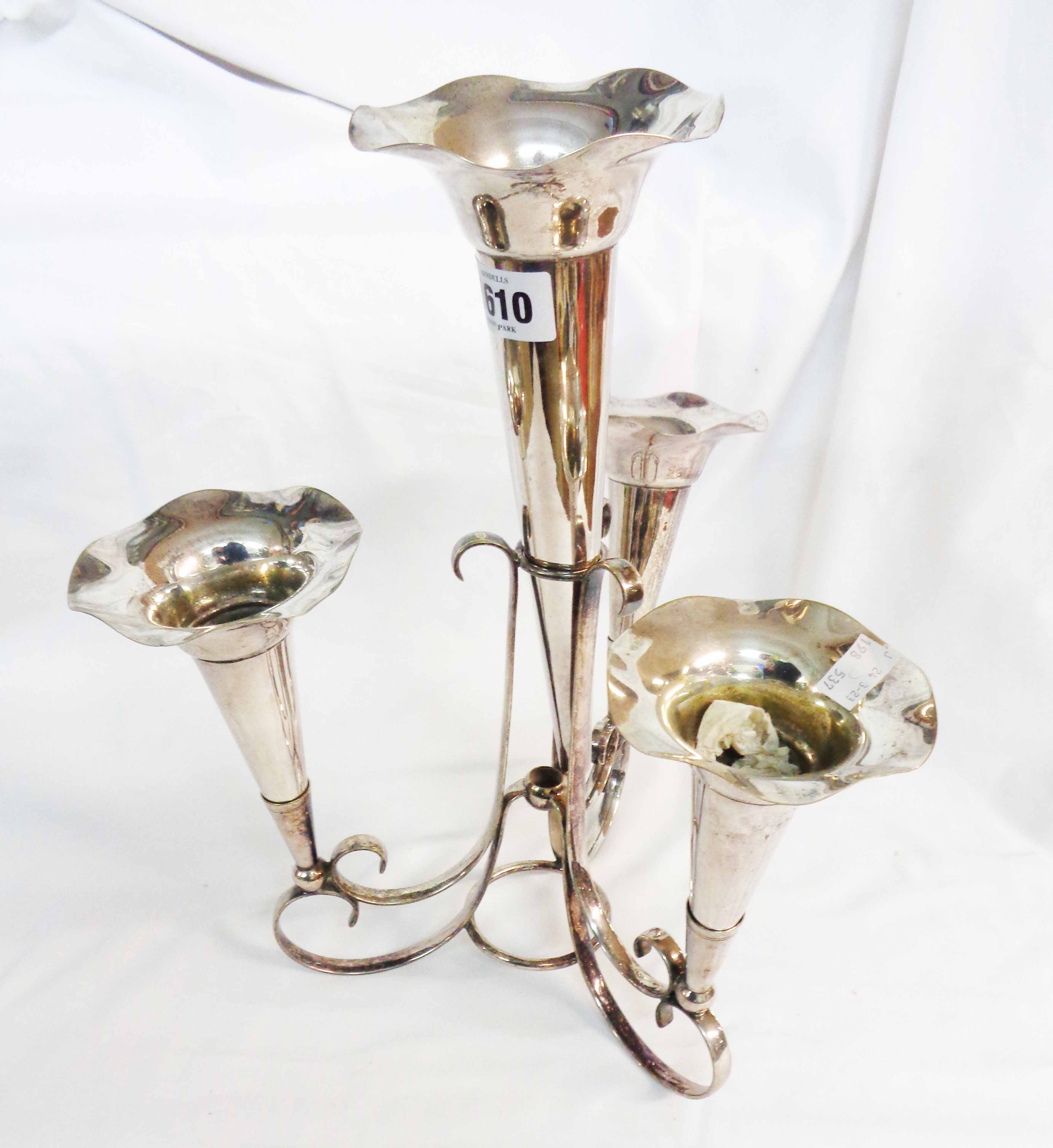 A silver plated epergne with three side trumpet vases and larger central vase, set on a scroll base