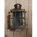 An old brass oil lantern of cage form with glass panes and GWR plaque to front - handle missing
