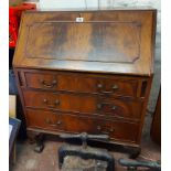 A 77cm Maple & Co. mahogany bureau with part fitted interior and three long graduated drawers, set