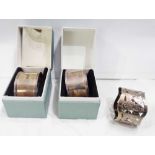 Two matching 1977 silver napkin rings - both boxed - sold with a silver plated example with engraved