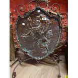 An Arts & Crafts Movement fire screen with central copper shield shaped panel decorated with a