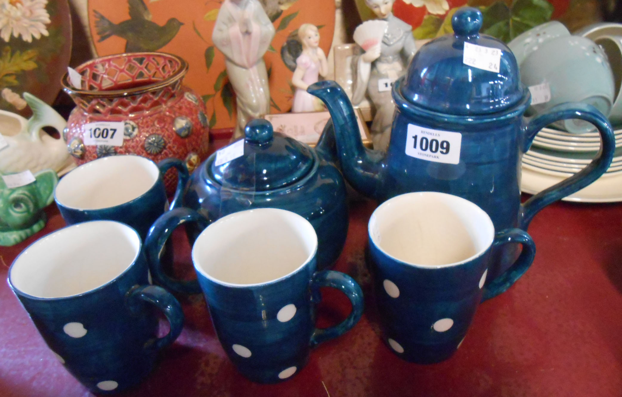 A vintage pottery part tea set comprising teapot, coffee pot and four mugs with blue painted and