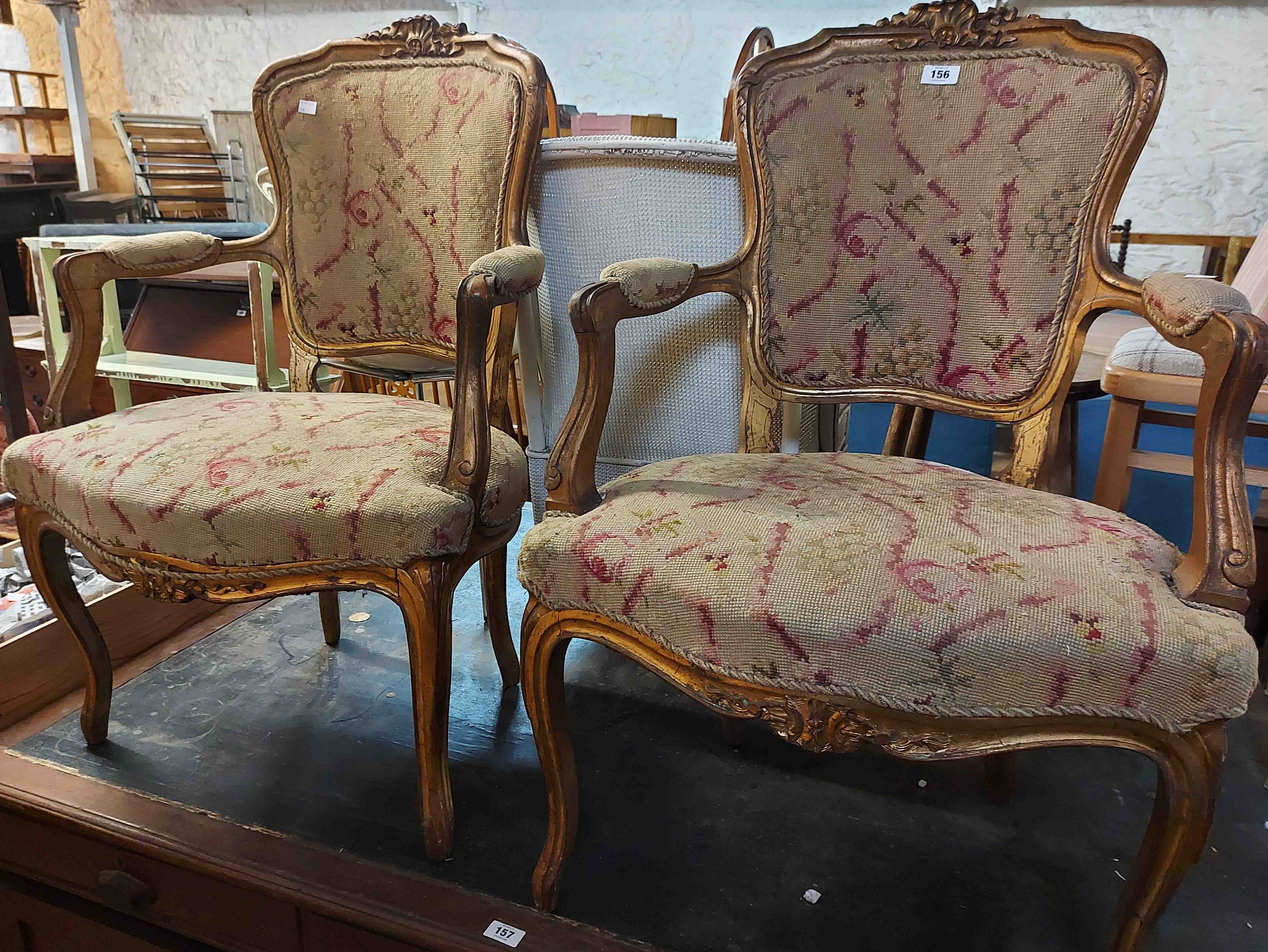 A pair of 20th Century giltwood fauteuil chairs in the Louis XV style with floral woolwork