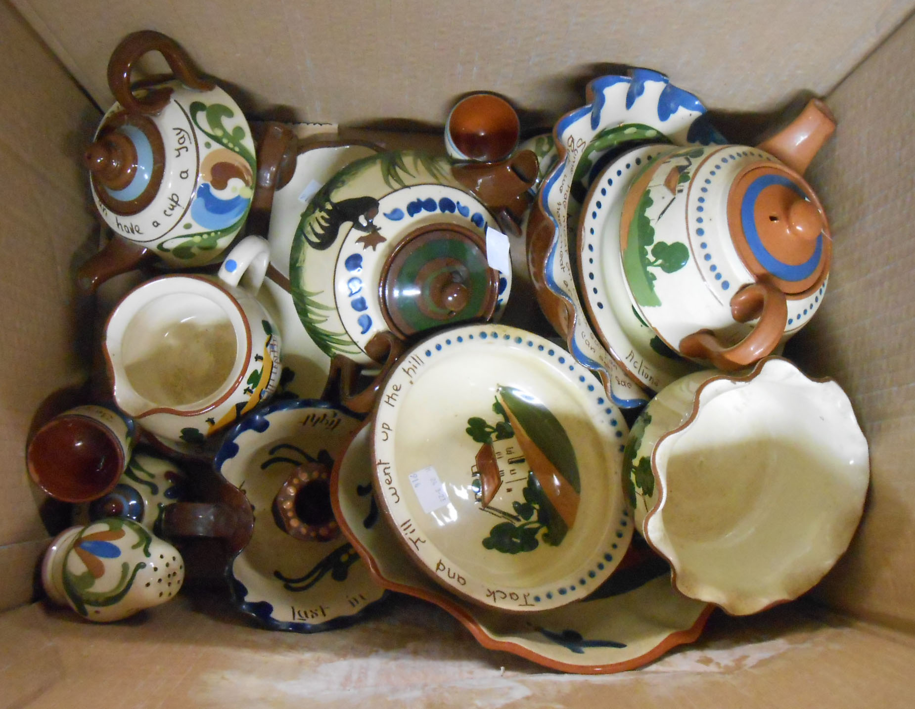 A box containing a quantity of Torquay motto ware including teapots, bowls, inkwell, candlestick,