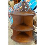 An old oak three tier wall hanging corner shelf unit with pierced scroll decoration to top and