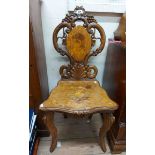 An antique Black Forest carved wood hall chair with stag and foliate decorated splat, the seat
