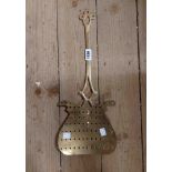 An antique brass cream skimmer