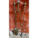 A set of brass fire irons comprising shovel, poker and tongs with ball finial decoration