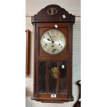 A vintage oak cased wall clock with visible pendulum and marked for Anglo Swiss Watch Co., Calcutta,
