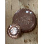A Middle Eastern copper charger with inlaid silver metal script and scroll decoration - sold with