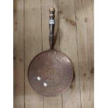 A large antique copper skimmer with wrought iron strapwork and turned wooden handle