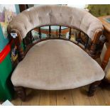 An Edwardian stained wood framed tub elbow chair with button back upholstery, set on turned front