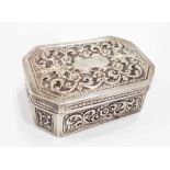 A colonial white metal snuff box of canted oblong form with all-over foliate scroll decoration and
