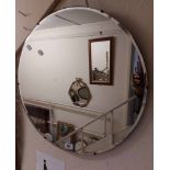 A vintage frameless bevelled circular wall mirror