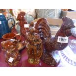 A quantity of brown glazed Dartmouth pottery items comprising two cockerel figurines, a knight