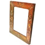 An Arts and Crafts copper clad framed bevelled oblong wall mirror with embossed fruit on branch