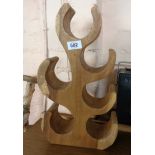 A carved wooden wine rack of stylised tree form