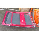 A large red painted metal flatbed trolley with folding handle