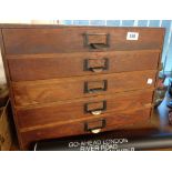 A vintage five drawer wooden collector's chest with copper finish label holder handles