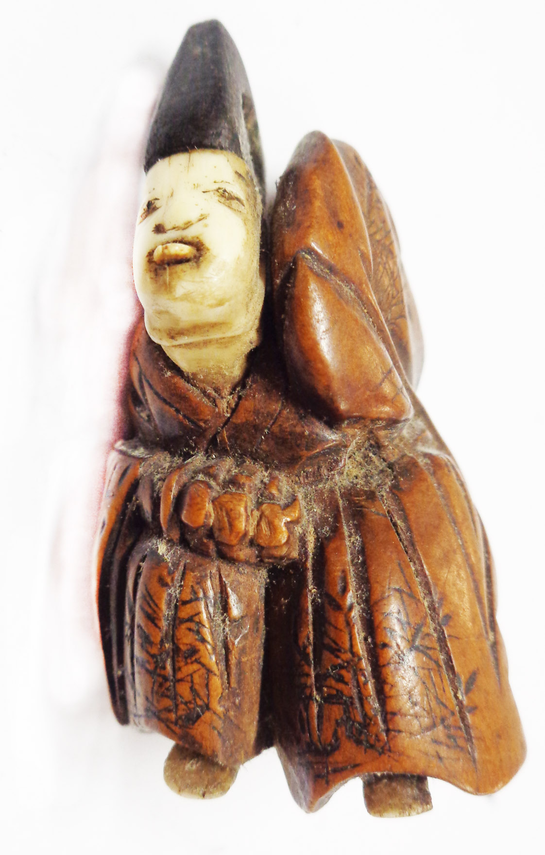 A 19th Century Japanese carved hardwood netsuke with carved bone face and feet