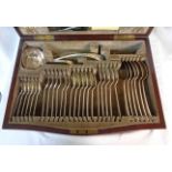 An antique inlaid walnut cased canteen containing a part set of silver plated cutlery