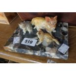 A cold painted spelter cat figure group depicting a mother and kittens, set on a marble plinth -