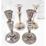 A pair of 19cm high silver candlesticks with embossed swag decoration and loaded circular bases -