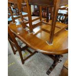 A 20th Century oak oval extending dining table with central stowed folding leaf, set on a