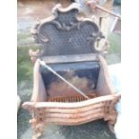 An antique cast iron fire basket with ornate scroll decoration to back, set on cabriole front legs